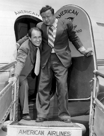 Jiří Voskovec s Janem Werichem na civilní fotografii vystupují z letadla při své první návštěvě Hollywoodu v roce 1941, fotograf neuveden. Fotografický fond IDU.